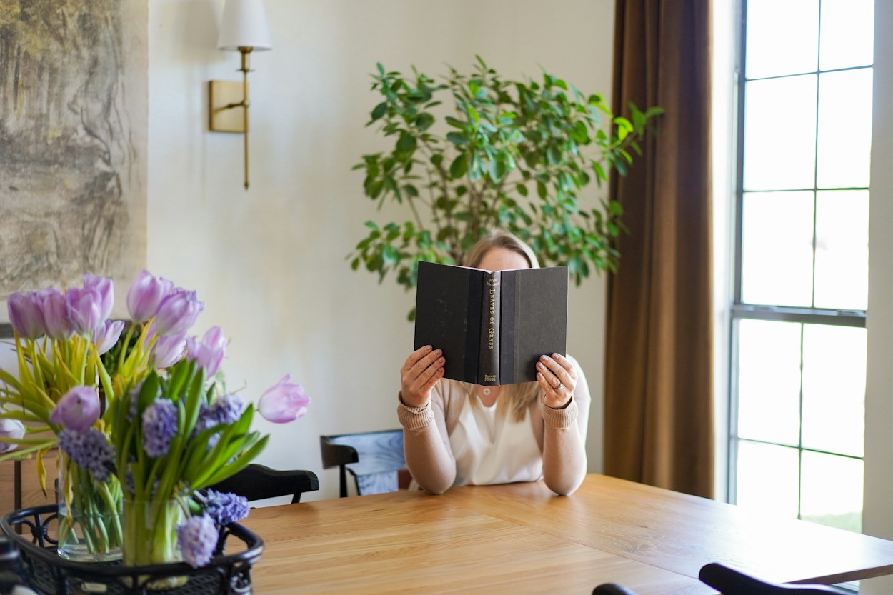 A woman reading at home while considering what she would like to do
